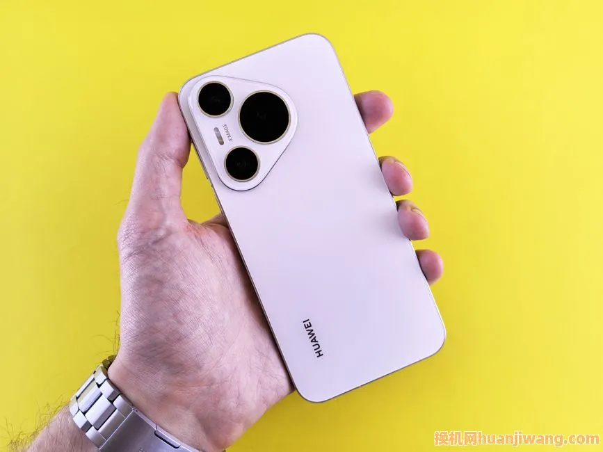 Close-up of a hand holding a modern smartphone with a yellow backdrop.