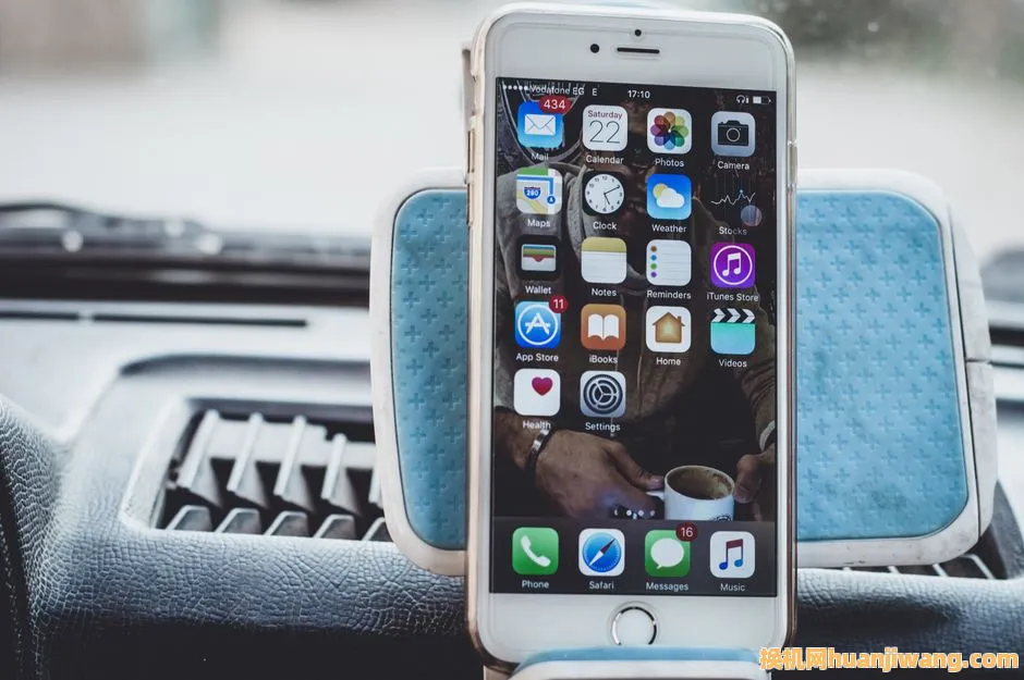 Close-up of a smartphone mounted on a car dashboard showing home screen with apps.