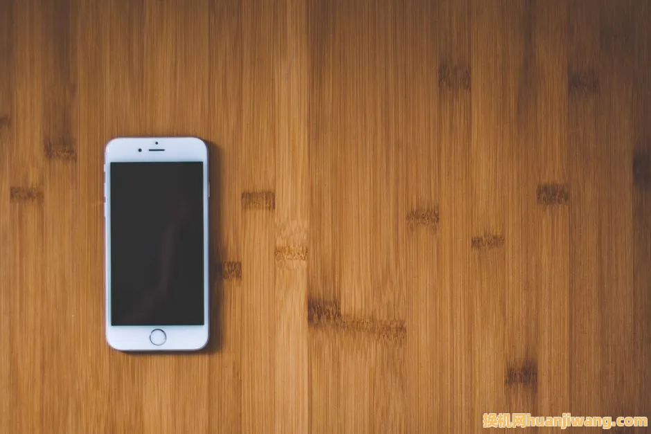 White smartphone on a smooth wooden surface, ideal for tech presentations.