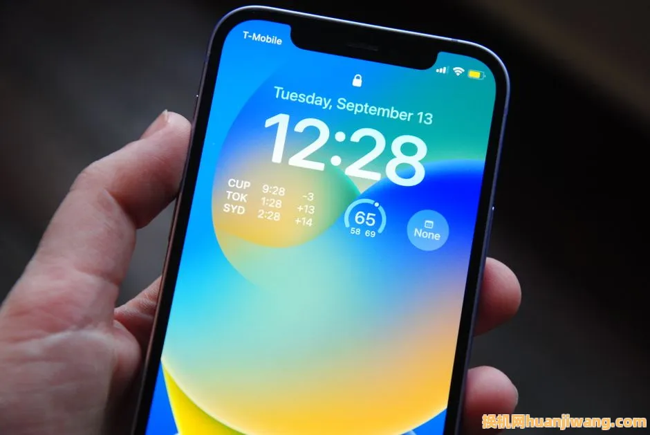 Close-up of a hand holding a smartphone showing a vibrant lock screen with time and date details.
