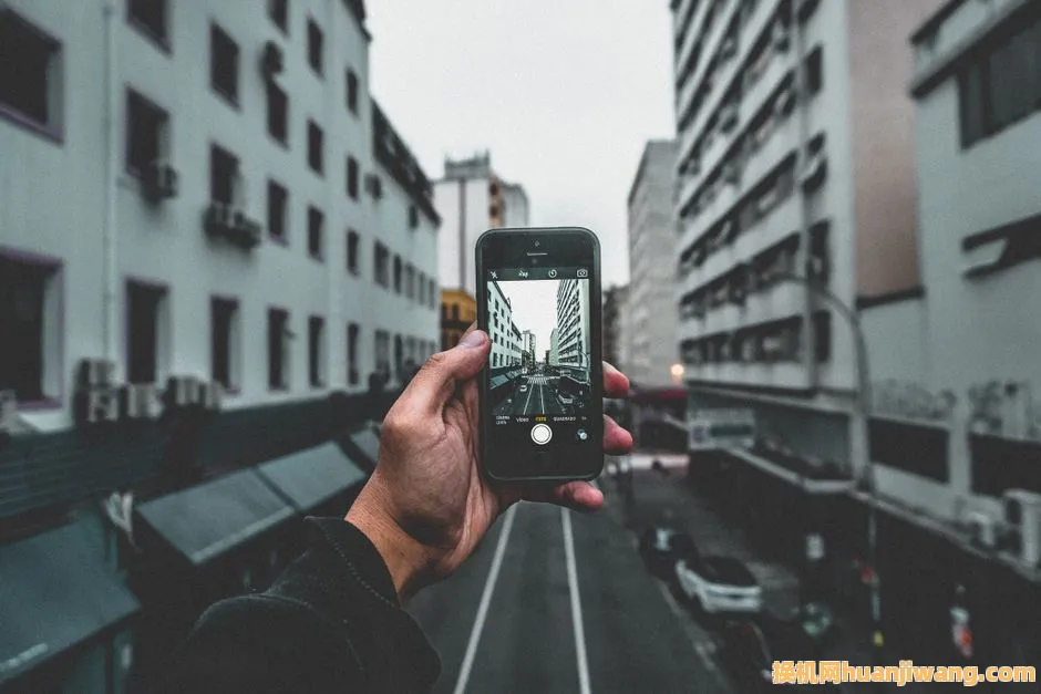 A city street view captured through a smartphone, highlighting urban architecture and perspective.